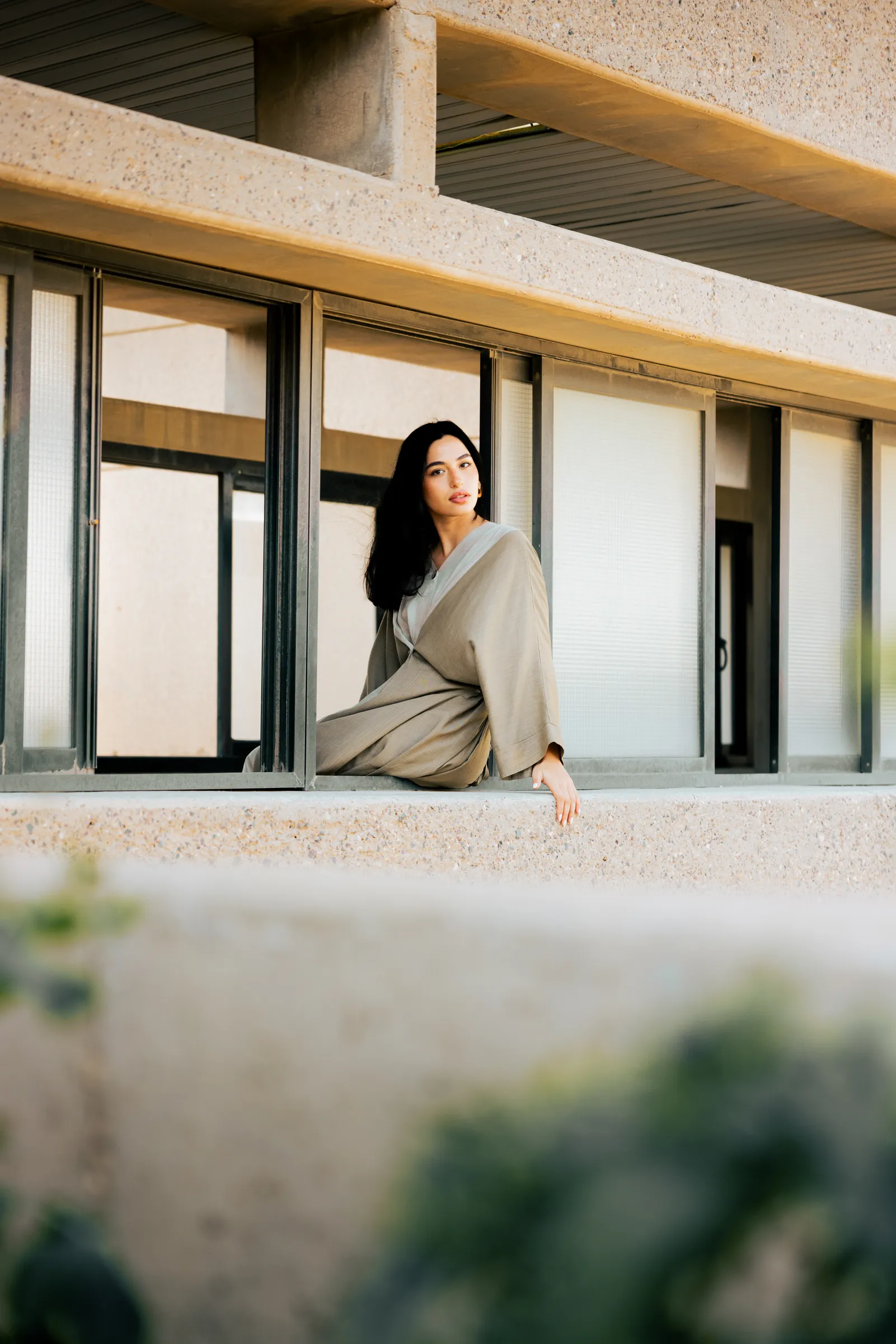 Model in an abaya posing against white walls in Kuwait