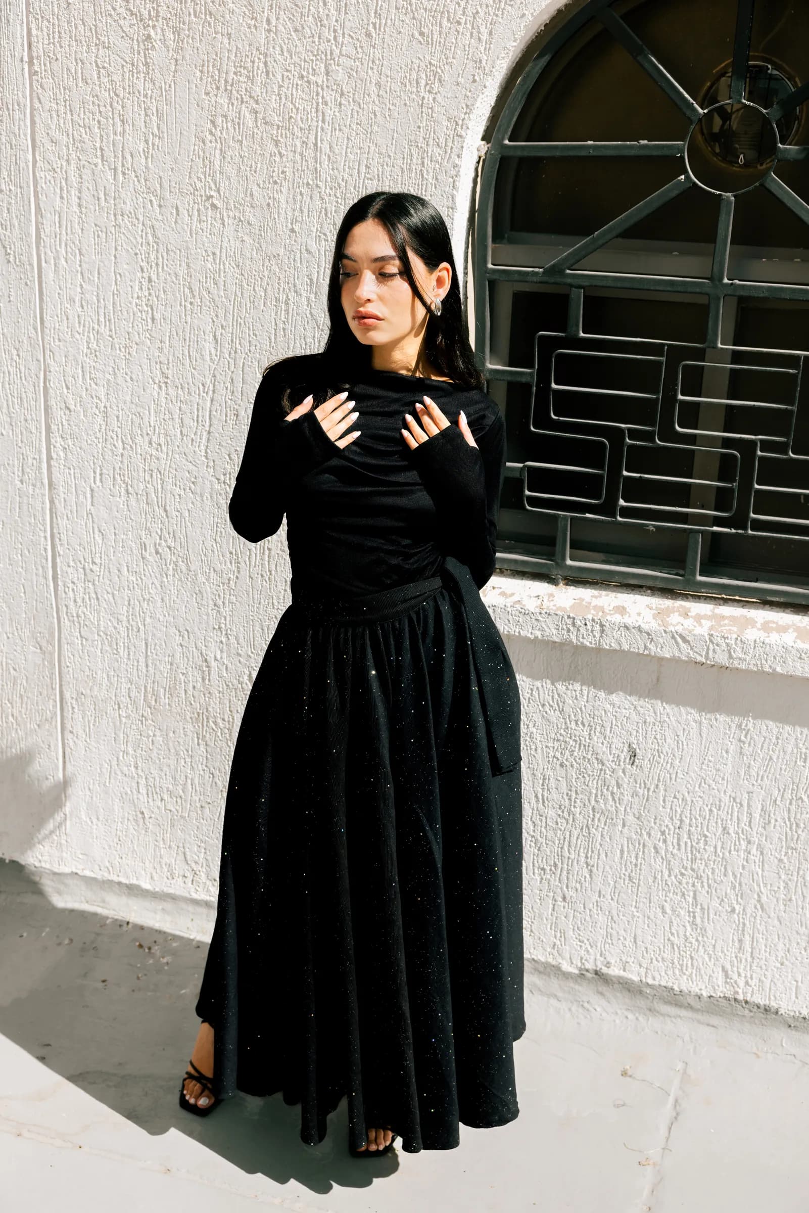Model in an abaya posing against white walls in Kuwait