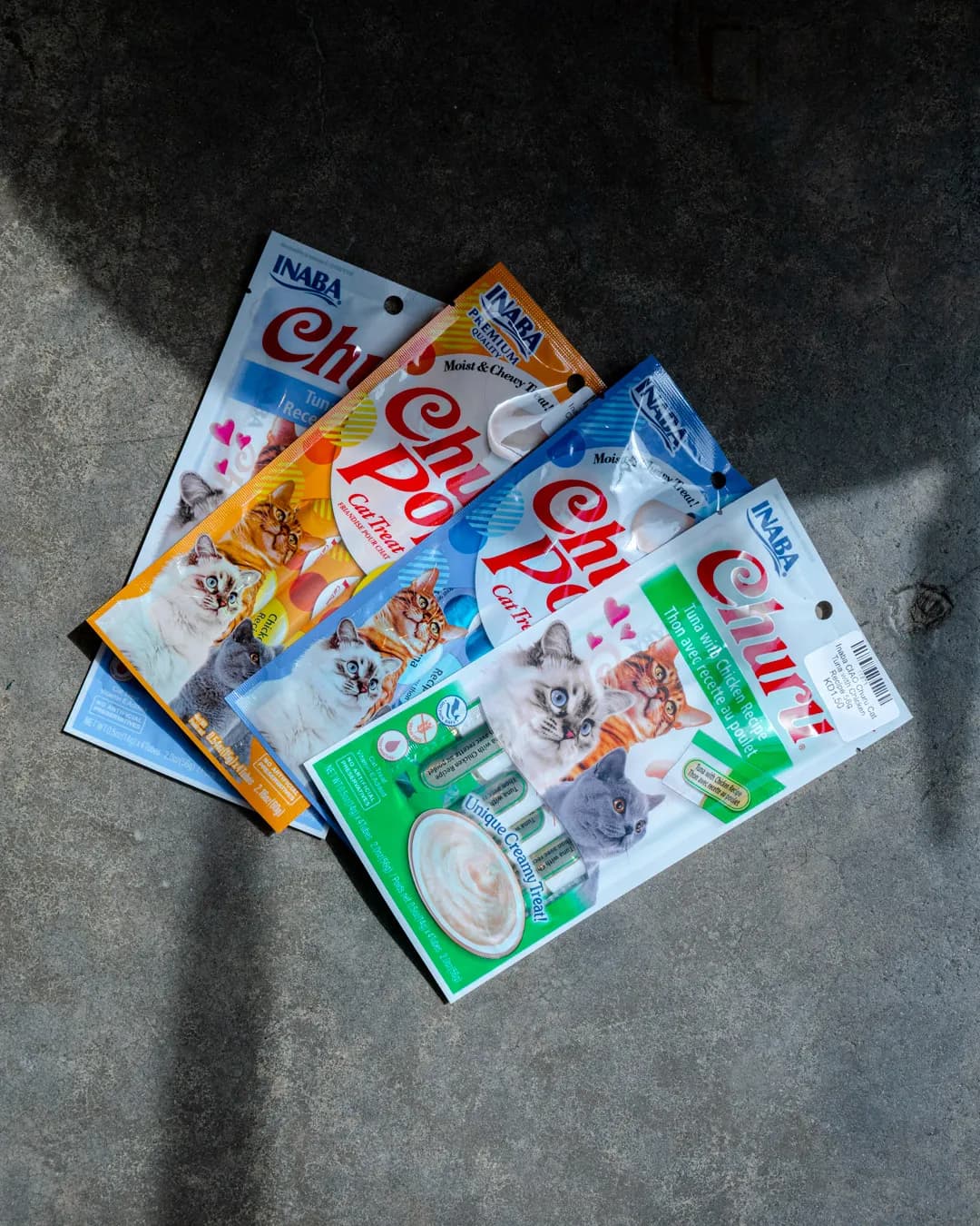 Bags of cat food arranged on a concrete floor