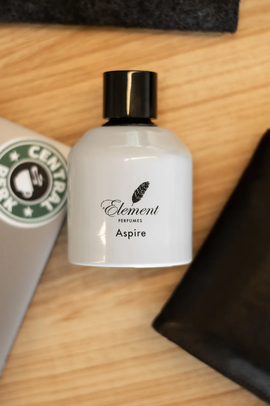 White perfume bottle with a black cap in soft window light